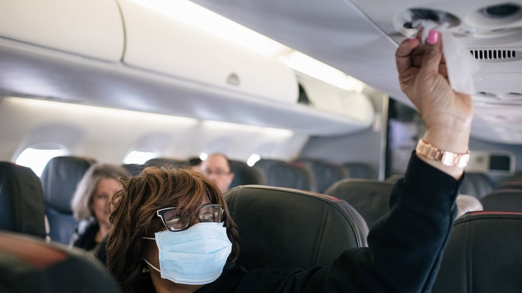 Acquanetta Garth wipes down her surroundings, as a precaution against the coronavirus, on her flight. File Photograph: Alyssa Schukar/The New York Times