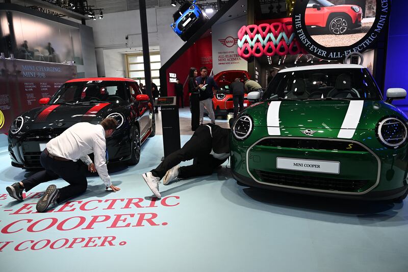 Staff and fans check out the cars on the Mini stand at the Beijing auto show. Photograph: Jade Gao/AFP via Getty Images