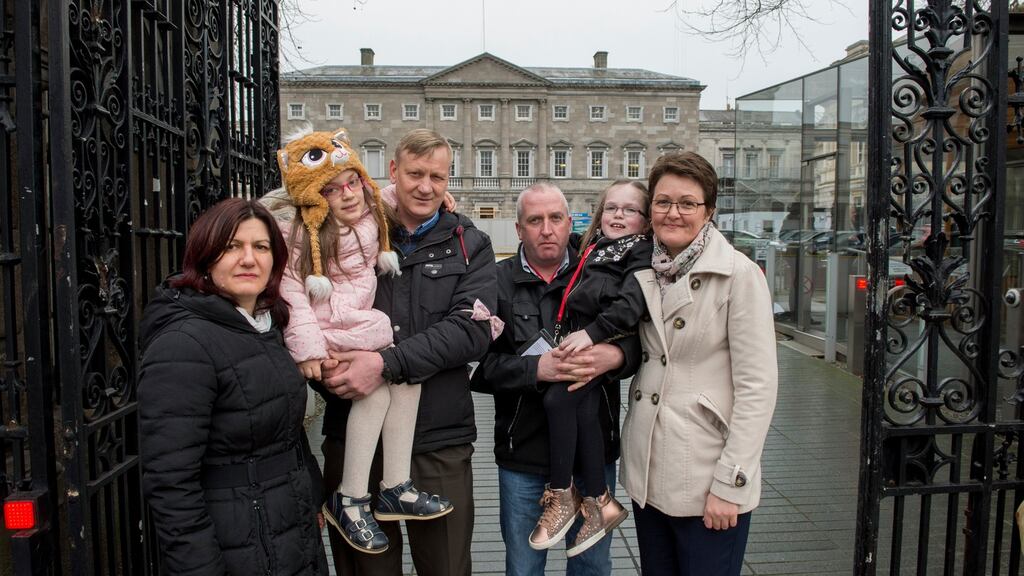 Elena and Costel Focsa with their daughter Cezy Focsa (11) and Padraig McIntyre and Barbara Frow with their daughter Grace McIntyre (10) outside the Dail. Photograph: Brenda Fitzsimons