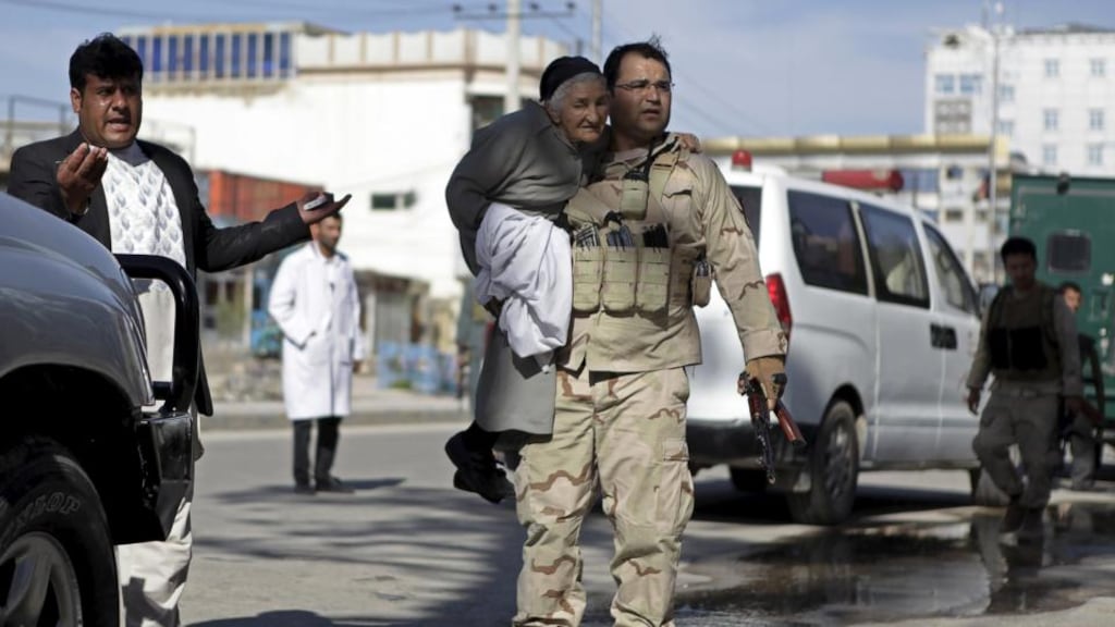 A member of the Afghan security forces carries a woman away from the site of an attack on a court in Mazar-i-Sharif, April 9th, 2015. Militants armed with rocket-propelled grenades and other weapons stormed the court in the northern Afghanistan city, killing the district police chief and two other officers, authorities said. Photograph: Anil Usyan/Reuters