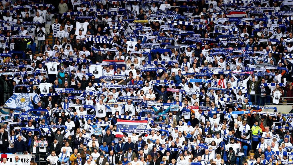 Leicester City fans commemorate Vichai Srivaddhanaprabha by holding up scarfs and signs during the Premier League match between Cardiff City and Leicester City at Cardiff City Stadium. Photograph: Michael Steele/Getty Images