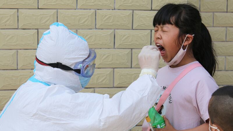 A medical staff member takes a swab sample from a child to test for coronavirus in Jiangxo, China. Photograph: Getty/AFP