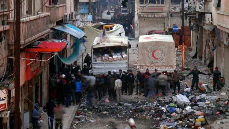 Syrian Arab Red Crescent trucks arrive in the besieged neighbourhoods of Homs to supply humanitarian aid yesterday. Photograph: Reuters