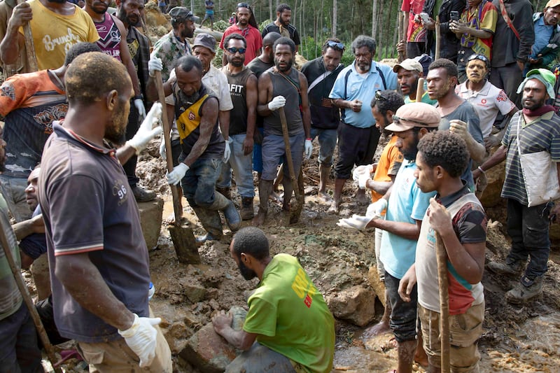 Villagers search through a landslide in Yambali village, in the highlands of Papua New Guinea. Photograph: Juho Valta/AP