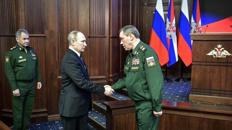 Vladimir Putin (C) shakes hands with Russia’s head of the armed forces general staff, Valery Gerasimov (R). Photograph: Alexey Nikols/Getty Images