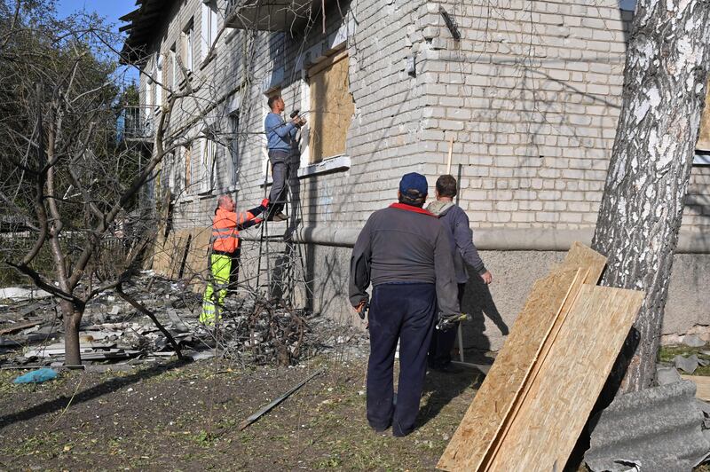 A man places a wooden board to protect a window of a building that was damaged following the recent Russian shelling in an urban settlement of Borova in Ukraine's Kharkiv region on October 4th. Photograph: Sergey Bobok/AFP via Getty Images