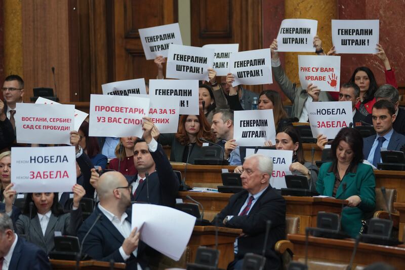 Opposition politicians hold up banners reading ‘general strike’ during the parliamentary session. Photograph: Darko Vojinovic/AP