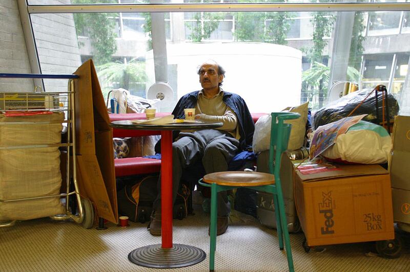 Mehran Karimi Nasseri's bench was surrounded by several luggage trolleys and many boxes and bags containing his growing hoard of belongings that were becoming a nest around him. Photograph: Christophe Calais/Corbis via Getty Images