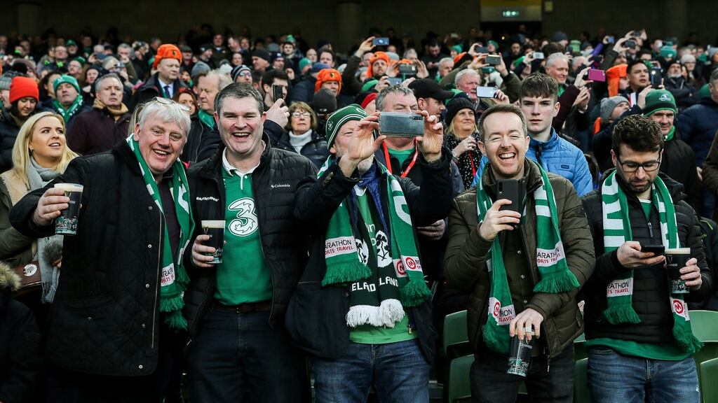 Ireland fans drink pints in the stand during the Six Nations opening match win over Scotland. Photo: Gary Carr/Inpho