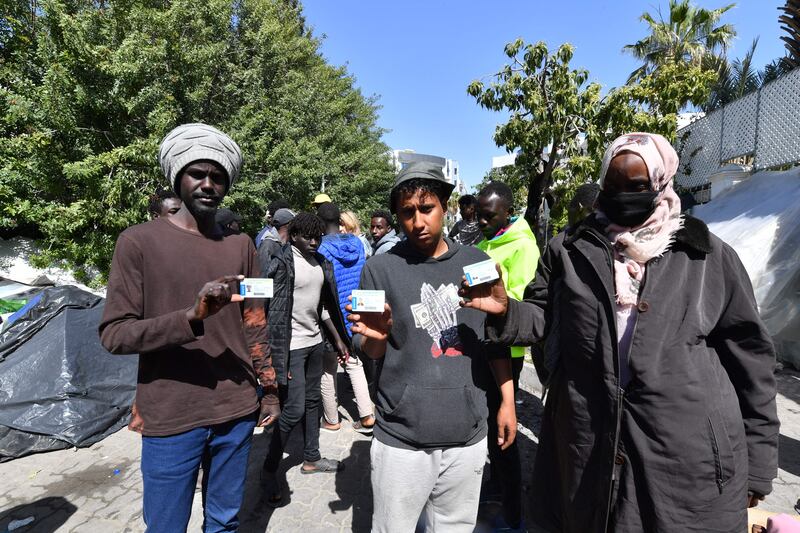Sudanese and Yemeni migrants show their refugee cards outside the offices of the International Organisation for Migration after Tunisian police dismantled a makeshift camp for refugees from sub-Saharan African countries in front of the UNHCR headquarters in Tunis. Photograph: Fethi Belaidvia Getty Images