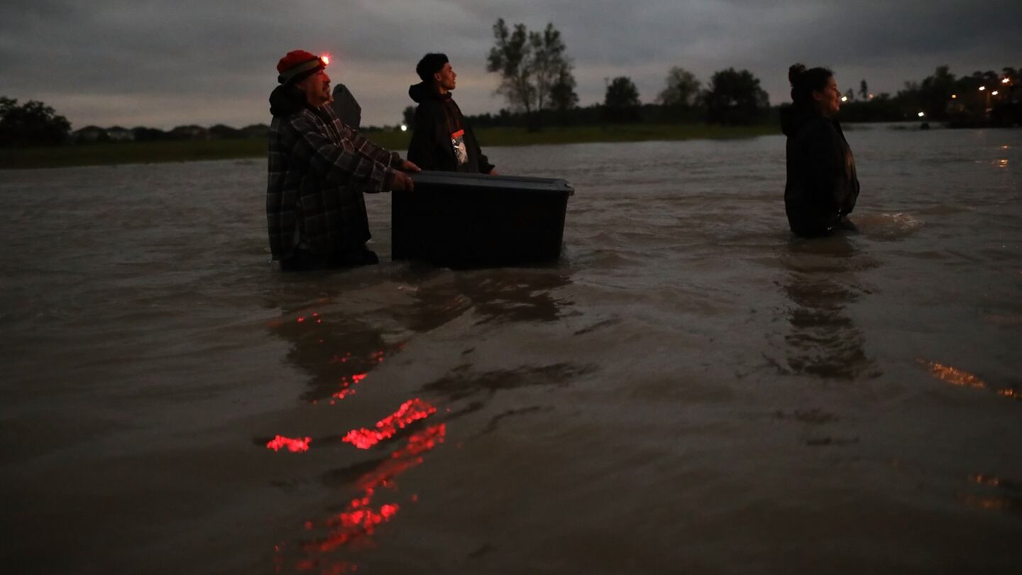A group of Houston residents move through waist deep water while evacuating their homes after severe flooding in north Houston. Photograph: Win McNamee/Getty Images.