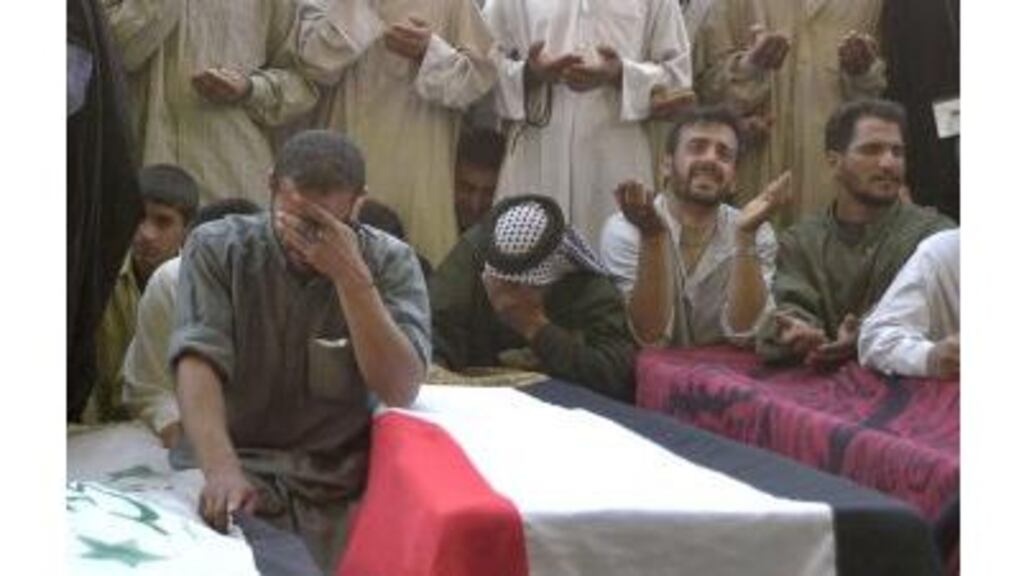 Iraqi mourners praying in front of coffins in the Immam Ali shrine in Najaf yesterday. US troops reportedly killed 64 members of local militia during heavy fighting in and around the city on Monday night