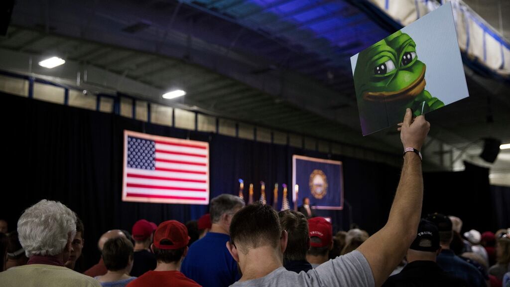 A man holds an image of Pepe the Frog, a character that has come to be associated with anti-Semitism and racism, during a Donald Trump campaign event in New Hampshire: According to a new report by the Anti-Defamation League, hundreds of Jewish journalists have been targeted by anti-Semitic attacks on Twitter during the 2016 presidential campaign. Photograph: Damon Winter/The New York Times