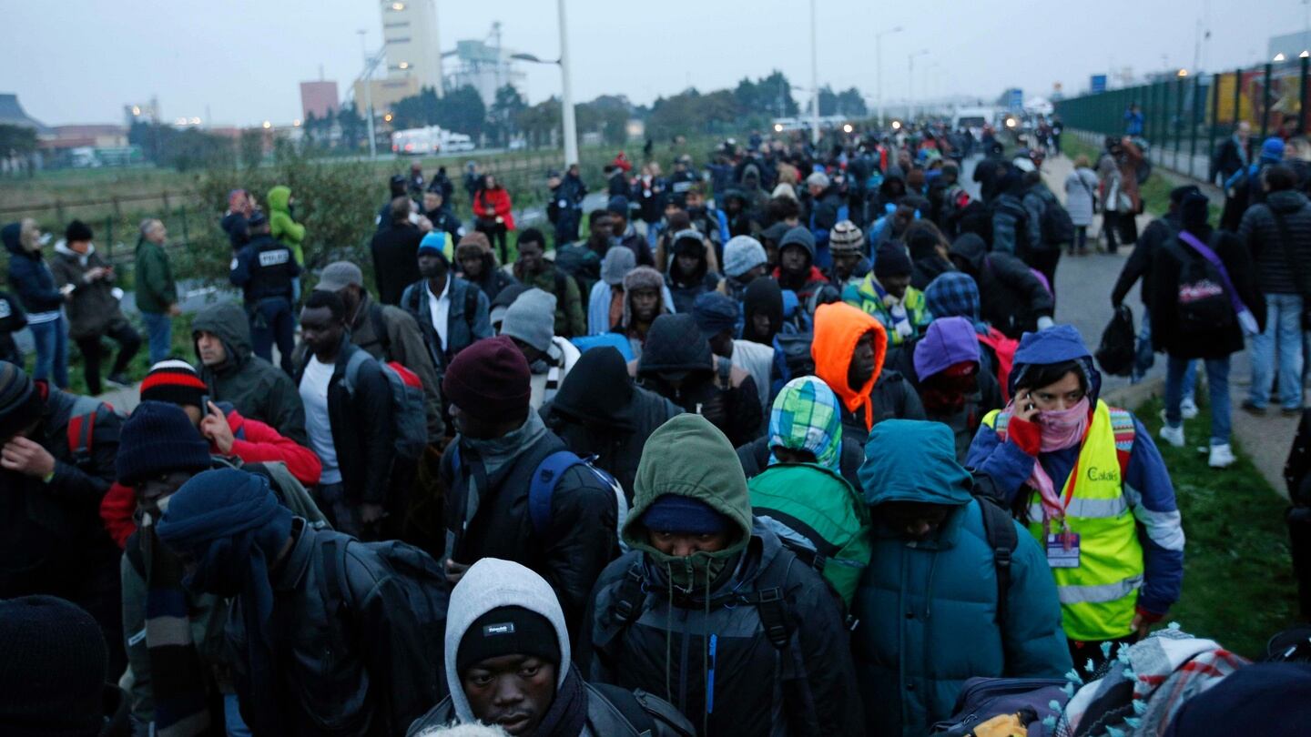 Migrants line-up to register at a processing centre. Photograph: AP Photo/Emilio Morenatti