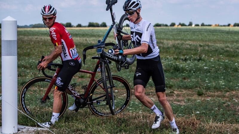 Froome and Belgium’s Jasper De Buyst get back on the road after crashing during the first stage. Jeff Pachoud/AP