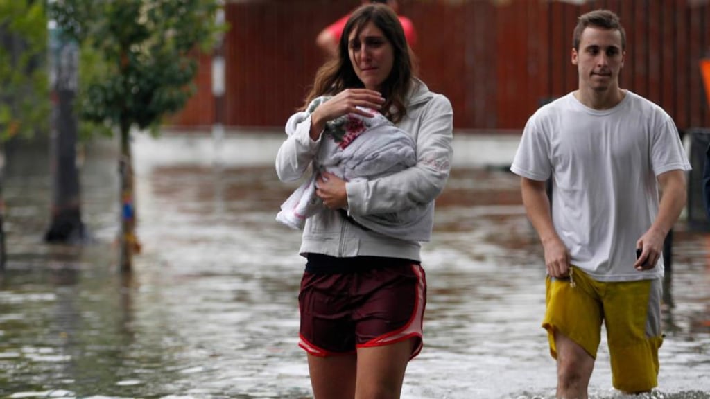 People wade through a flooded street after a rainstorm in Buenos Aires. Record flash floods in Argentina have killed at least 54 people this week, officials have confirmed. Photograph: Enrique Marcarian/Reuters
