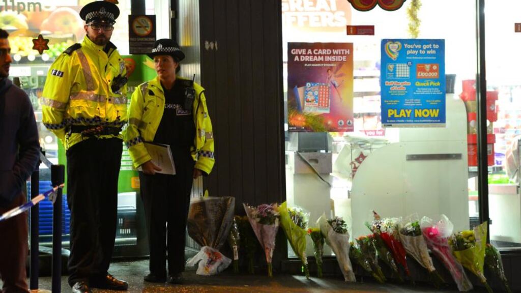 Officers from Police Scotland stand next to floral tributes to people who were killed and injured today when a bin lorry lost control and hit pedestrians in central Glasgow. Photograph: Mark Runnacles/Getty Images.
