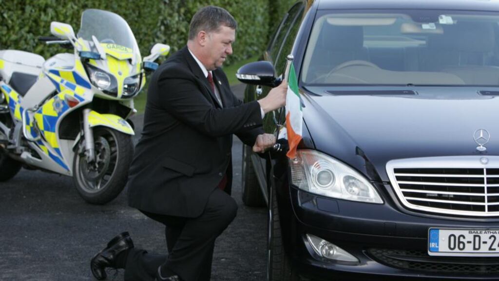 Garda driver Gerry Buttner fixes the Tricolour to the presidential car. Photograph: Frank Miller