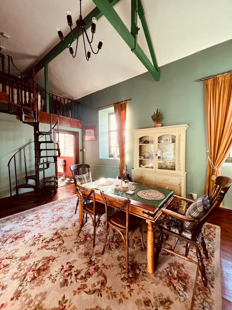 A spiral staircase leads to a mezzanine with a living area