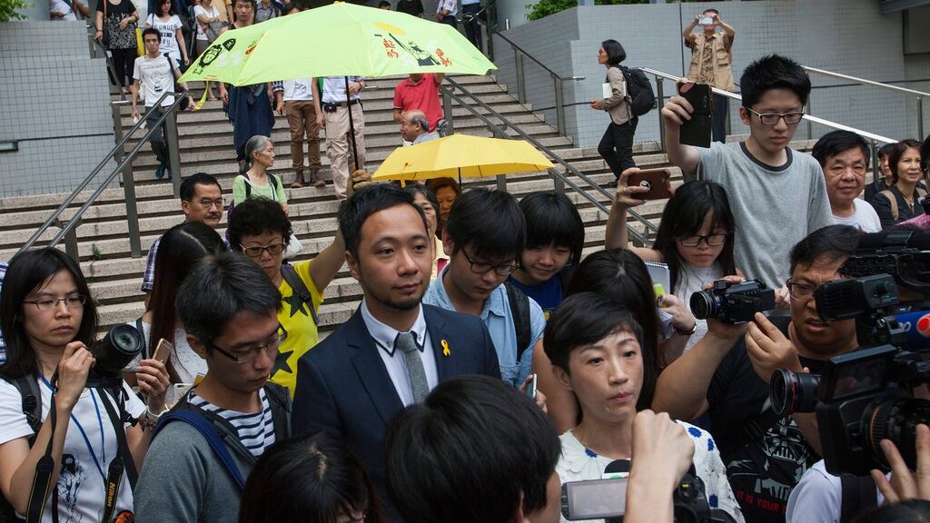 Ken Tsang (centre) arriving at Kowloon City Magistrates Court for his trial over charges of assaulting police officers in Hong Kong. His supporters held up yellow umbrellas, the symbol of Hong Kong’s democracy movement. Photograph: Alex Hofford/PA