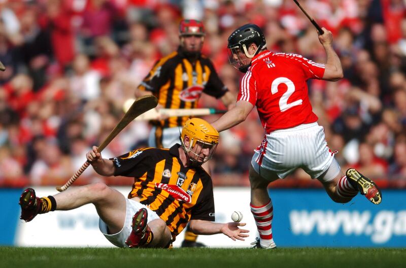 Kilkenny's Richie Power gives a handpass from the ground towards a colleague as Cork's Shane O'Neill closes in during the 2008 All-Ireland semi-final at Croke Park. Photograph: Caroline Quinn/Inpho