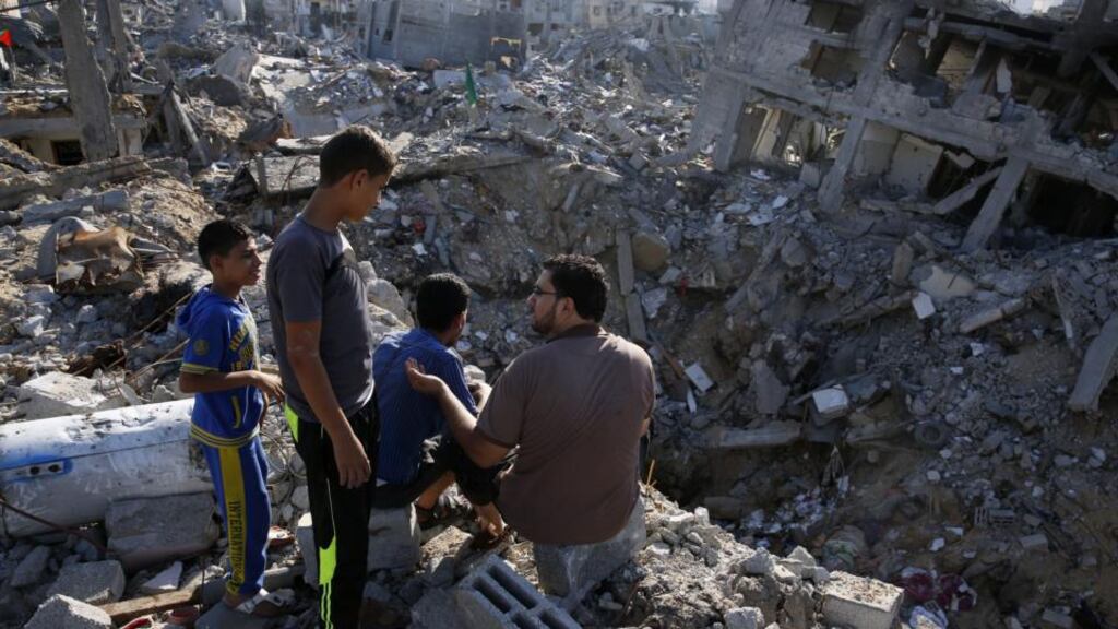 A Palestinian man and three children survey the destruction in Shejaia. Photograph: Roberto Schmidt/AFP/Getty Images