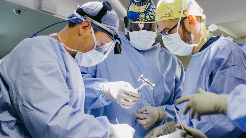 Mark Shrime and Jason Savage, Max Fax Surgeons, work in the Mercy Ship operating room alongside mentee Diegane Faye. Photograph: Lara Arkinstall
