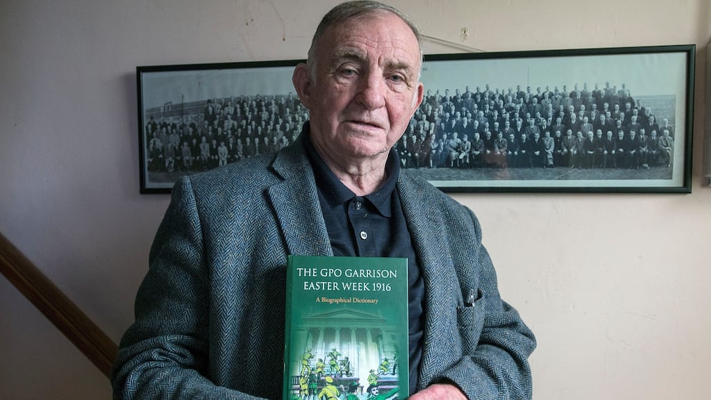 Jimmy Wren, who has written a book, The GPO Garrison Easter Week 1916, at his home in Donnycarney. On the wall is a group photograph of Rising participants, taken in 1936. Photograph: Dave Meehan