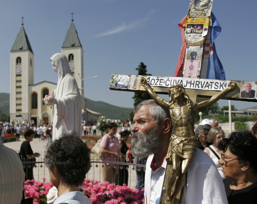 Pilgrims walk around a statue of the Blessed Virgin Mary near the church of St James in Medjugorje, Bosnia and Herzegovina. Photograph: Amel Emric/AP