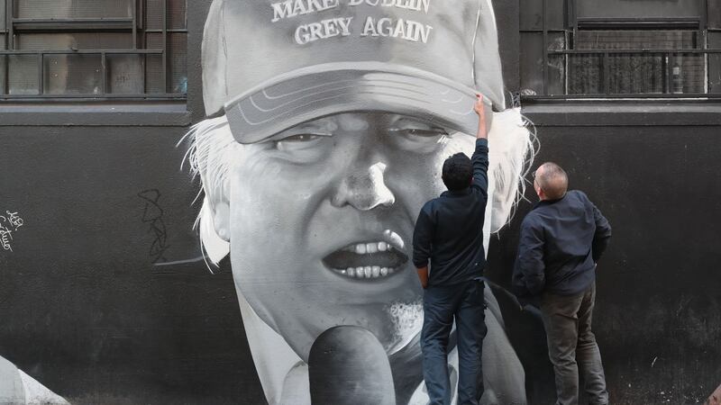 Members of the public look at a mural of US President Donald Trump in Dublin city centre by the artist group Subset. File photograph: Niall Carson/PA