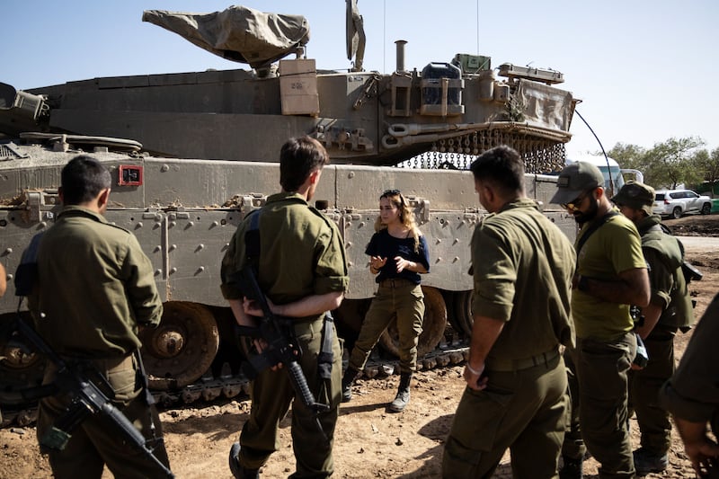 An Israeli army instructor talks to soldiers next to a Merkava battle tank at the border with the Gaza Strip in southern Israel on Thursday. Photograph: Christophe Petit Tesson/EPA