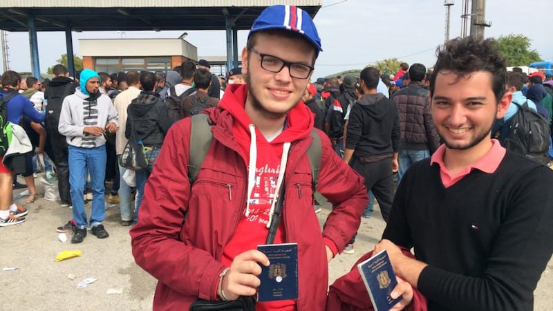 Sami Zbedeh (left) and Basher Zitouni show their Syrian passports outside the Opatovac transit camp for migrants in eastern Croatia. Photograph: Daniel McLaughlin