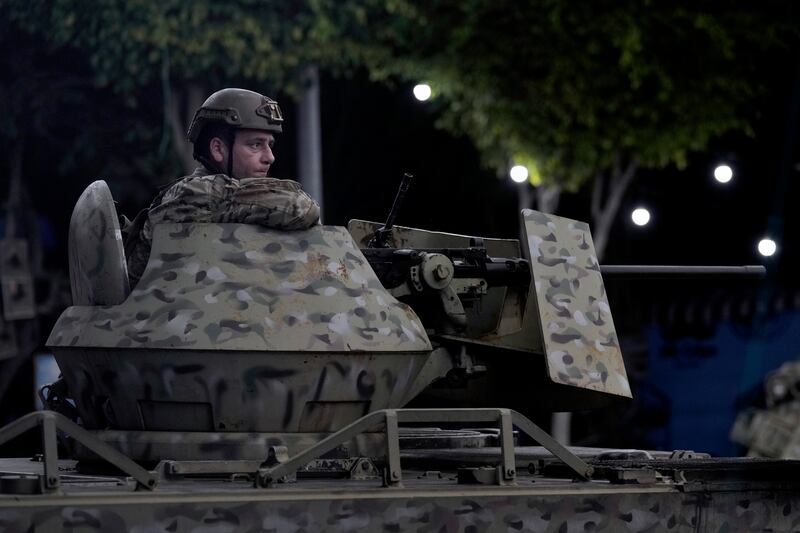 A Lebanese army soldier sits on the top of an armoured personnel carrier at the site of an Israeli airstrike in Beirut’s southern suburbs. Photograph: Bilal Hussein/AP