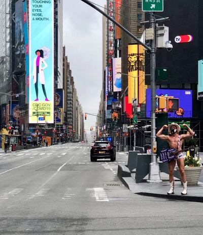 Street performer Robert John Burck, known as The Naked Cowboy, plays guitar in the almost deserted street in New York. Photograph: Mark O'Toole