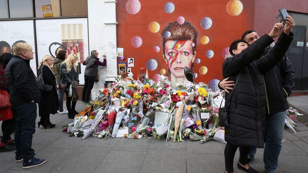 People take a selfie photograph in front of a mural of British singer David Bowie, whose death was announced on his  official social media accounts  on January 11th 2016.  Photograph: Justin Tallis/ AFP/Getty  Images