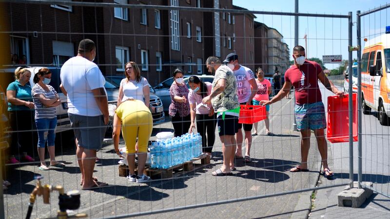 People, under quarantine after a coronavirus outbreak at a slaughterhouse of the Tönnies company, receive goods. Photograph: Ina Fassbender/AFP via Getty Images