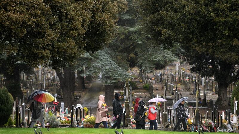 Visiting graves on a rain-drenched afternoon at Glasnevin Cemetery during the eighth annual Flowers for Magdalenes memorial event. Photograph: Dara Mac Dónaill/The Irish Times