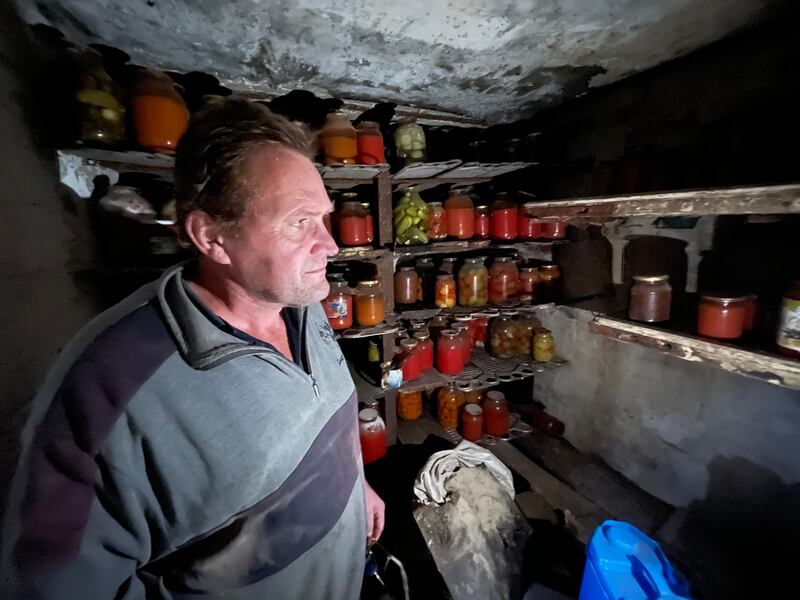 Andriy Pivovar in the cellar of his family's cottage in Mospanove, northeastern Ukraine, where his family store pickled vegetables and jams for winter, and he spent much of this year sheltering from shells and missiles fired over this village when it was on the frontline of the Russia-Ukraine war. Photograph: Daniel McLaughlin