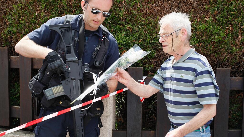 A man gives flowers to a French policeman on guard on June 14th, 2016, outside a house in Magnanville where a man claiming allegiance to the Islamic State group killed a French policeman and his partner on the night of June 13th. Photograph: Matthieu Alexandre/AFP/Getty Images