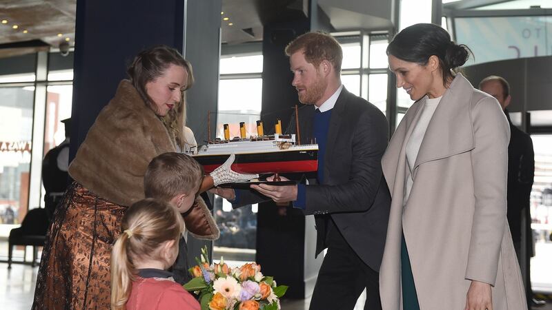 Prince Harry and Meghan Markle are presented with a model of the Titanic by Lleyton Jackson  and Rosie Jackson  during a visit to Titanic Belfast maritime museum. Photograph: Joe Giddens/PA Wire.