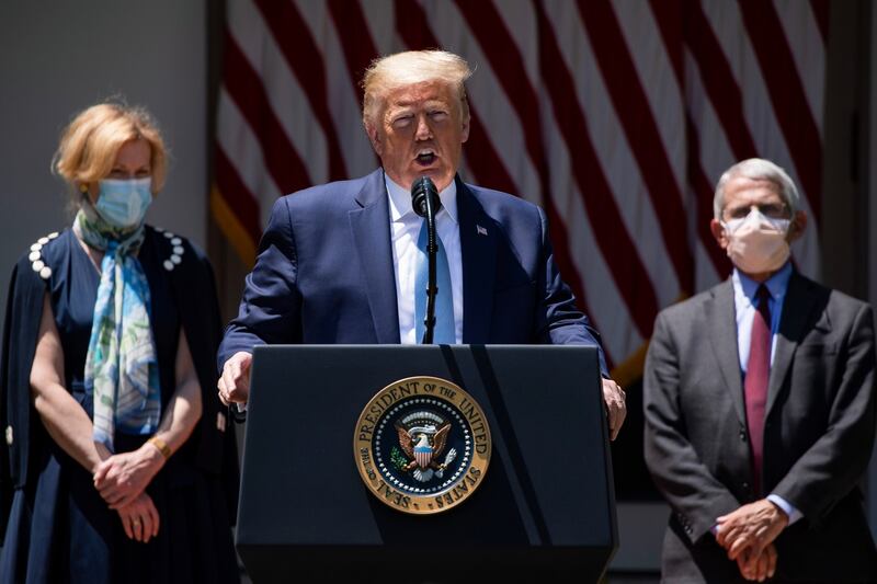 Flanked by Dr Debbie Birx (left) and Dr Anthony Fauci, both wearing masks, Trump discusses coronavirus vaccination projects at the White House on May 15th. Photograph: Samuel Corum/The New York Times