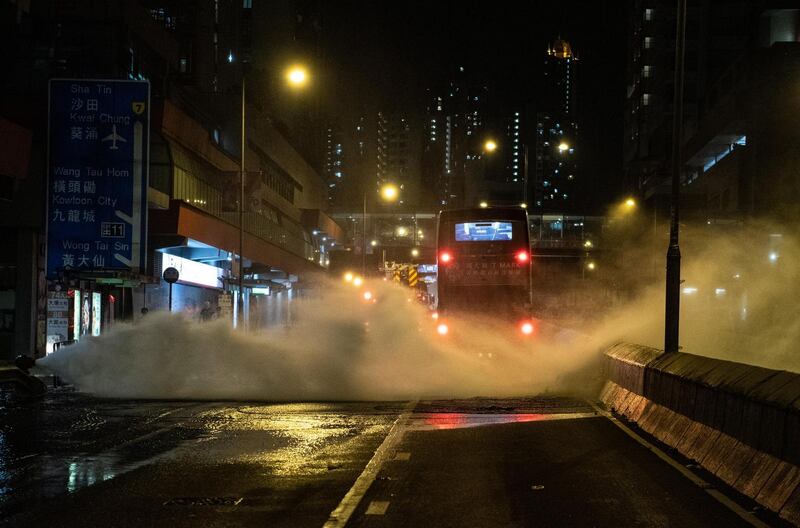 A bus drives through the jet of a broken fire hydrant during a protest against a government ban on face masks in Wong Tai Sin, Hong Kong on Friday. Photograph: Getty images