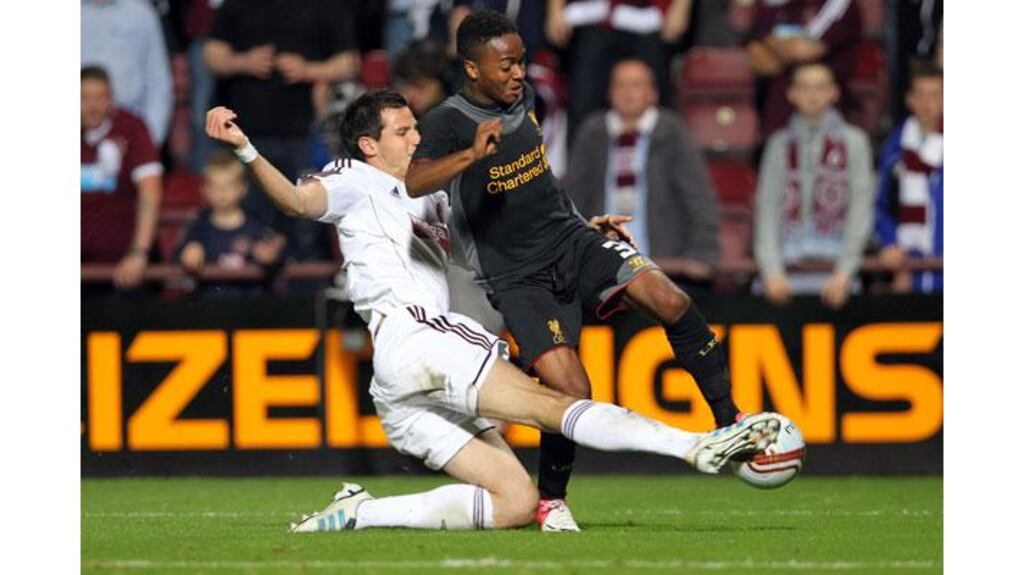 Raheem Sterling of Liverpool competes with Ryan McGowan of Hearts during their Uefa Europa League play-off round match at Tynecastle Stadium, Edinburgh. - Photograph: Ian MacNicol/Getty Images