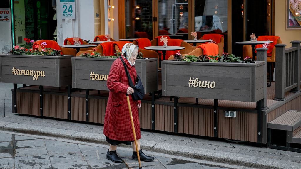 An elderly woman walks past an empty restaurant in Moscow, Russia. Photograph: Yuri Kotchekov/EPA