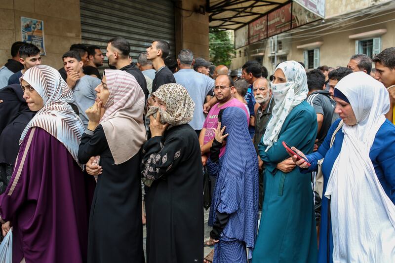 People wait in line outside a bakery to buy bread in the centre of Khan Younis, in the southern Gaza Strip. Photograph: The New York Times