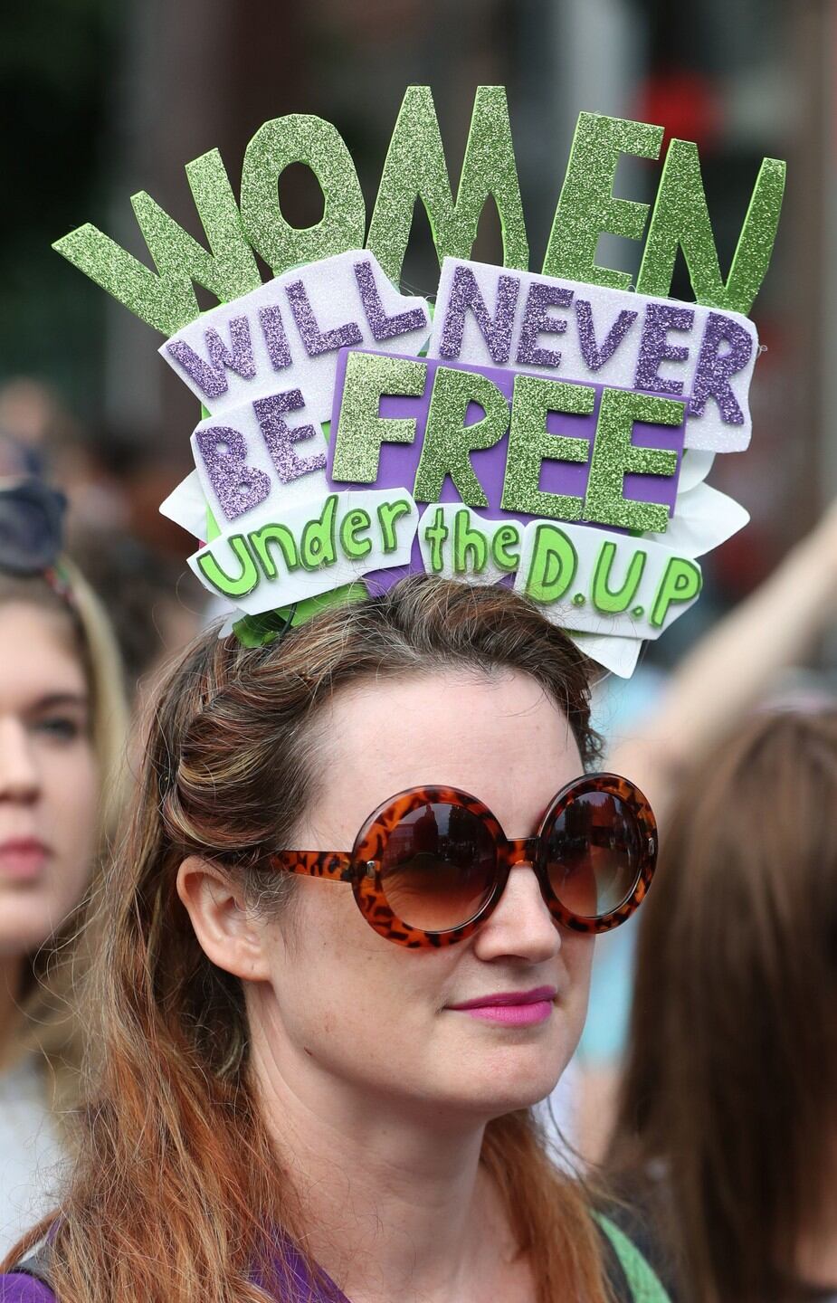 A woman wearing a hat critical of the Democratic Unionist Party at the Processions march. Photograpyh Niall Carson/PA