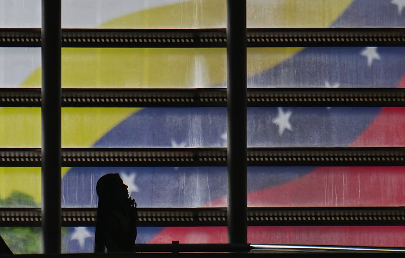 A woman walks past a mural with the Venezuelan national flag in Caracas on October 28, 2025. Photograph: Juan Barreto/ Getty Images
