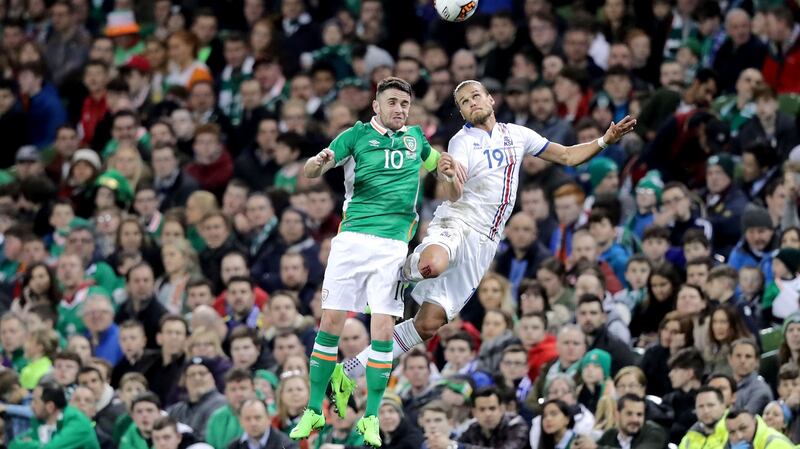 Robbie Brady challenges Rúrik Gíslason in the air. Photo: Morgan Treacy/Inpho