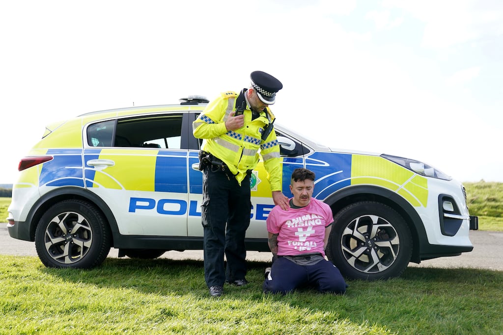 A protester is detained by police at the start of the Grand National at Aintree racecourse, Liverpool. Photograph: PA Images