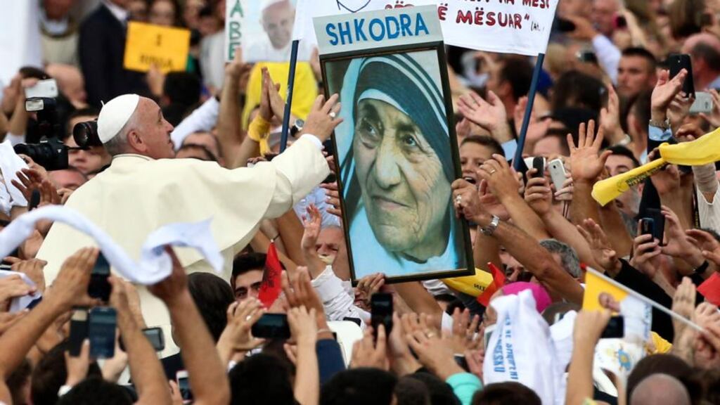 Pope Francis waves to a poster of the ethnic Albanian missionary Mother Teresa as he is driven through Tirana yesterday. Photograph: Hector Pustina/AP
